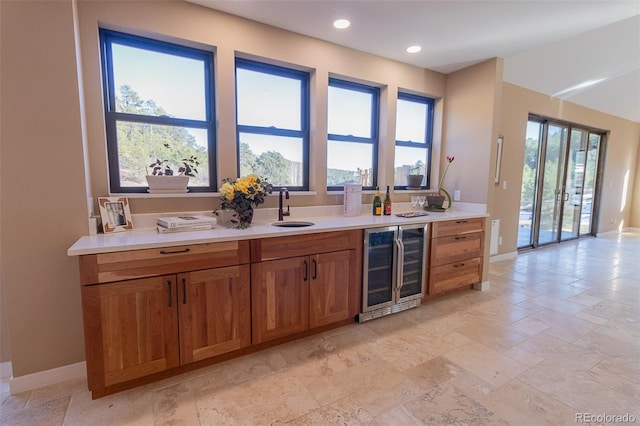 20101 Spring Gulch Rd, Morrison, CO 80465 - kitchen featuring wine cooler, a sink, brown cabinets, baseboards, and light countertops