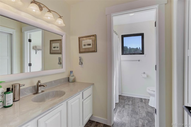 20101 Spring Gulch Rd, Morrison, CO 80465 - bathroom featuring vanity, wood finished floors, toilet, baseboards, and a shower with shower curtain