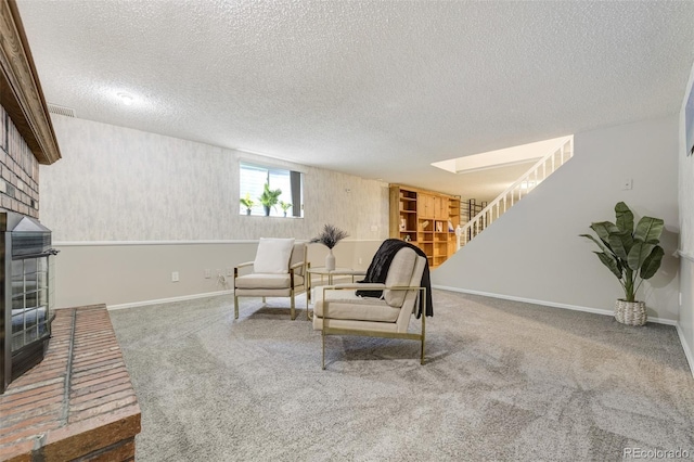 living room with a fireplace, stairway, carpet floors, a textured ceiling, and baseboards