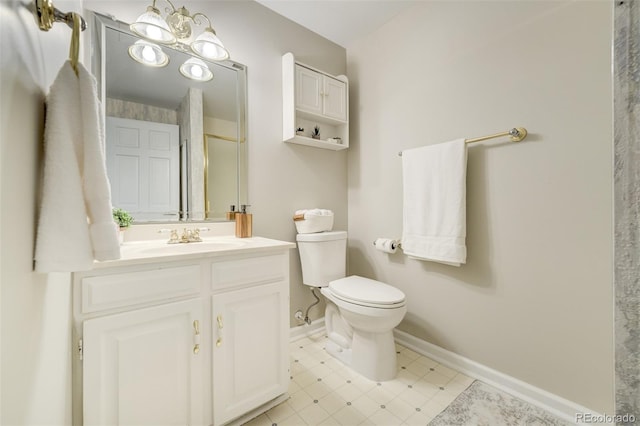 bathroom with toilet, vanity, and baseboards