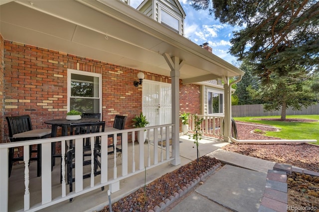 entrance to property with covered porch and brick siding
