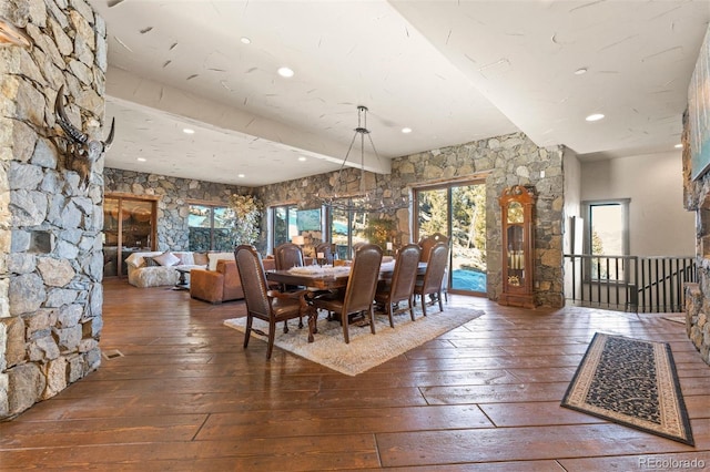 unfurnished dining area with dark wood-type flooring and beamed ceiling