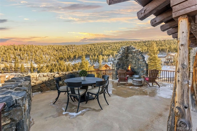 snow covered patio featuring a fire pit