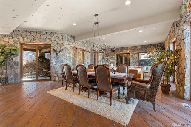 dining area with beamed ceiling, hardwood / wood-style floors, and a wealth of natural light