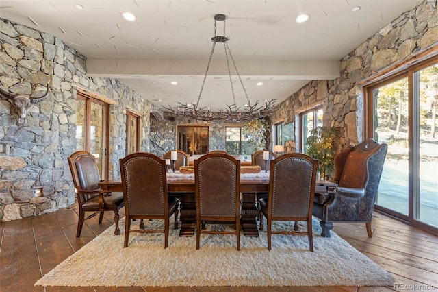 dining area featuring beam ceiling and hardwood / wood-style flooring