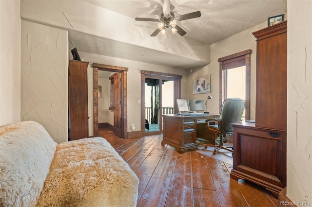 home office with dark hardwood / wood-style floors and ceiling fan