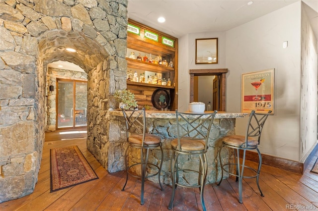 bar with hardwood / wood-style floors