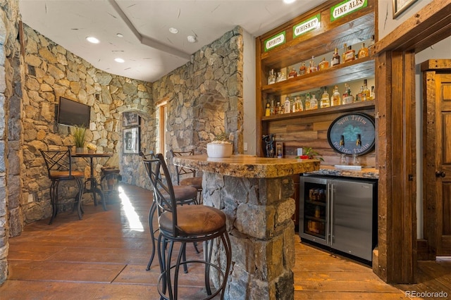 bar featuring wood-type flooring and beverage cooler