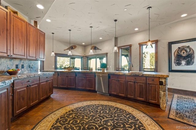 kitchen featuring stainless steel dishwasher, dark hardwood / wood-style floors, sink, and hanging light fixtures