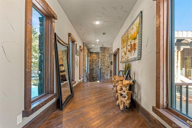 hallway with a healthy amount of sunlight and dark hardwood / wood-style flooring