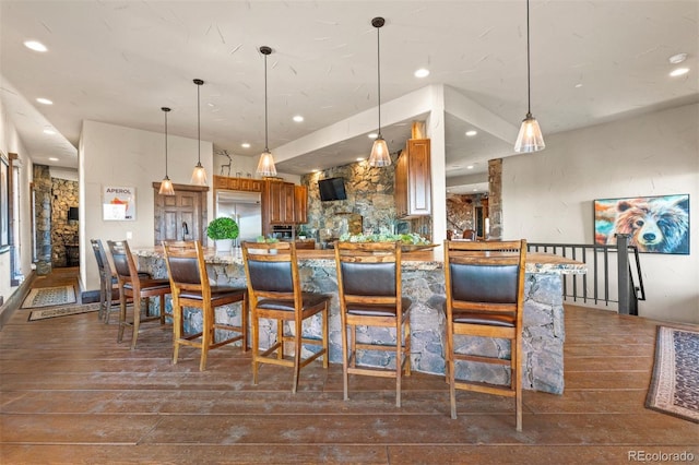 142 Outpost Ln, Evergreen, CO 80439 - kitchen with brown cabinets, stainless steel built in fridge, dark wood-style floors, recessed lighting, and hanging light fixtures