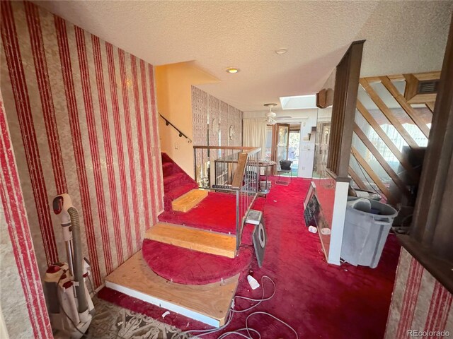 stairs with wallpapered walls and a textured ceiling