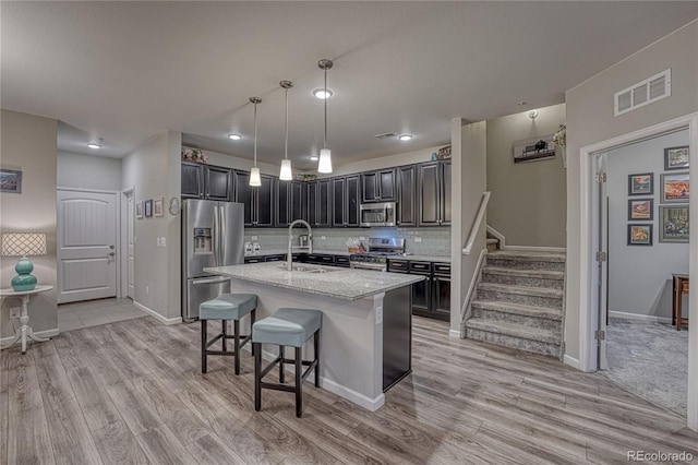 kitchen with visible vents, a sink, light wood finished floors, and stainless steel appliances