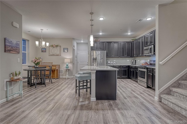 kitchen with baseboards, light wood-style floors, and stainless steel appliances