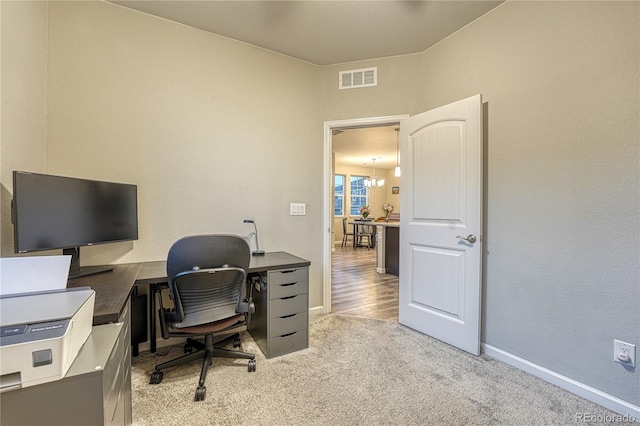 office space featuring visible vents, baseboards, a notable chandelier, and light colored carpet