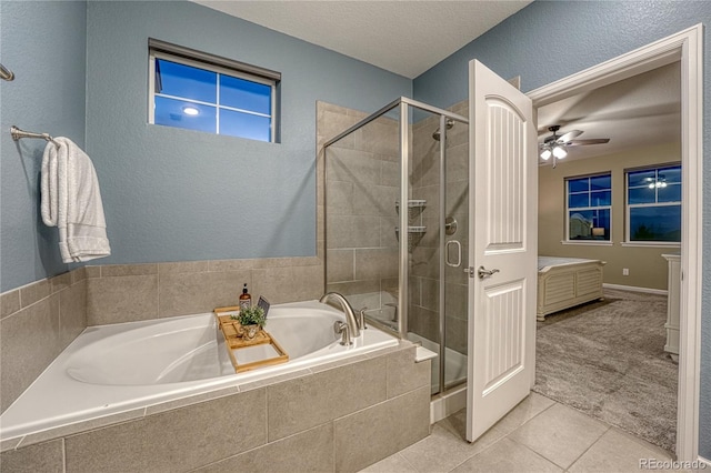 bathroom featuring tile patterned flooring, a garden tub, ceiling fan, and a stall shower