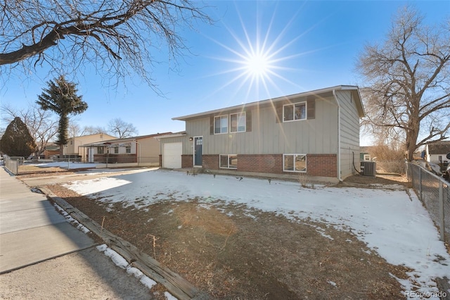 view of front of home featuring a garage and central AC