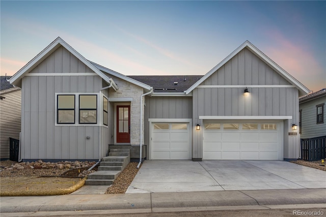 modern inspired farmhouse featuring board and batten siding, driveway, a shingled roof, and a garage