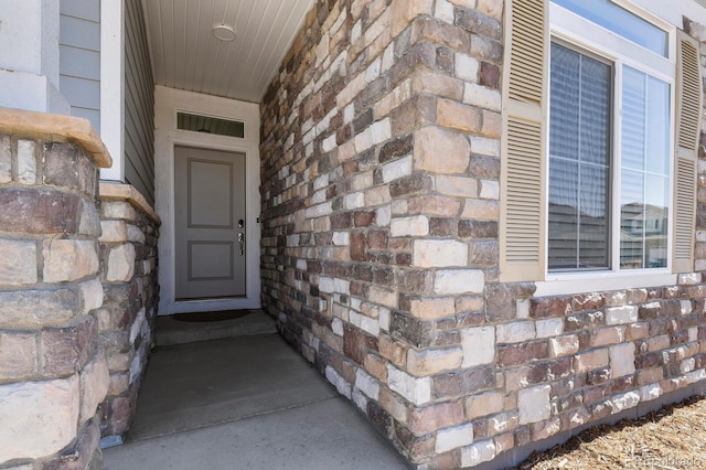 view of exterior entry with visible vents and stone siding