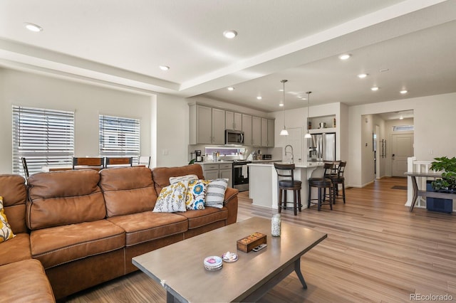 living area with recessed lighting and light wood-style flooring