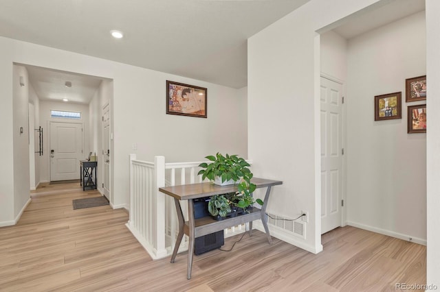 hallway with light wood-style flooring and baseboards