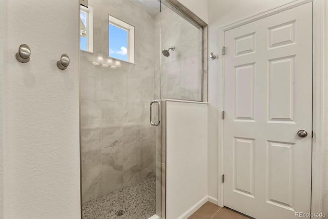 full bathroom featuring a shower stall and tile patterned flooring