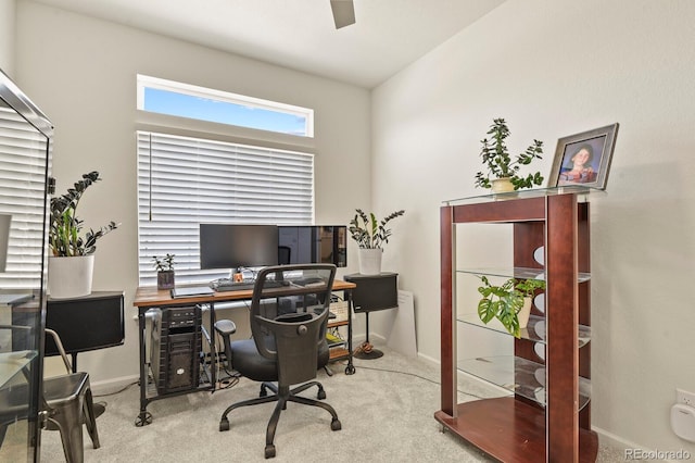 carpeted office space with baseboards and ceiling fan