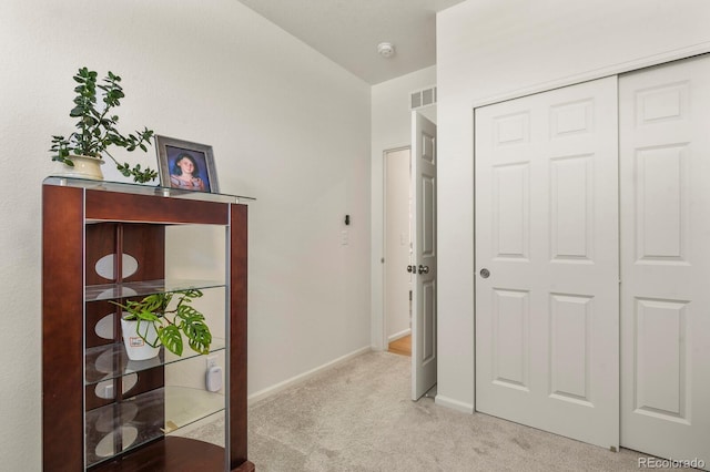 hall featuring baseboards, visible vents, and carpet floors