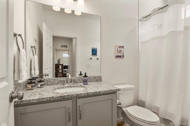 bathroom with vanity, toilet, and visible vents