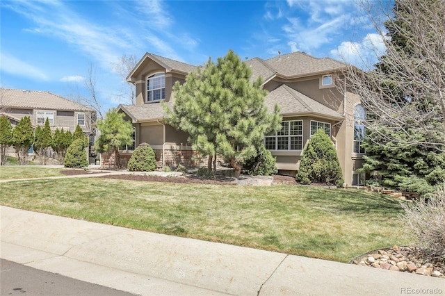 obstructed view of property featuring stucco siding and a front yard