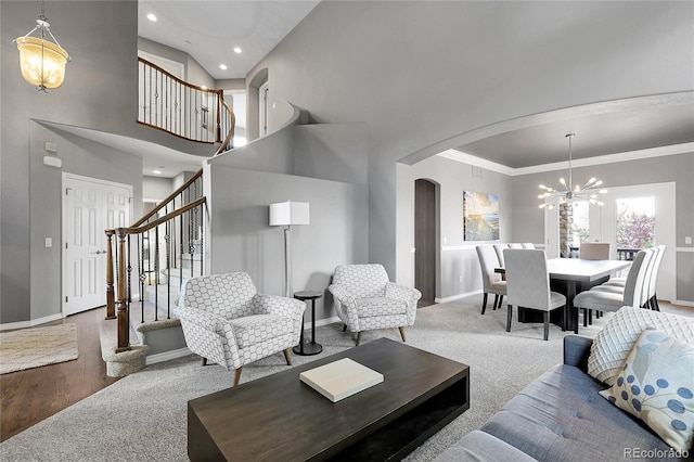 living area with ornamental molding, baseboards, arched walkways, and stairs
