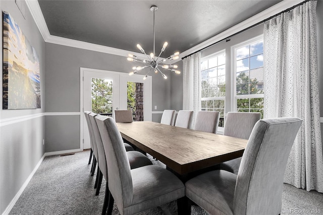 carpeted dining space featuring a chandelier, ornamental molding, and baseboards