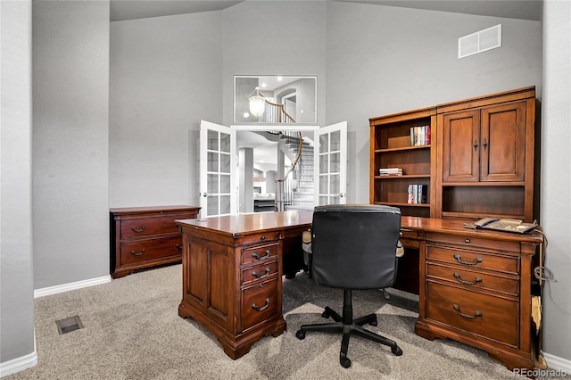 office area with light colored carpet, baseboards, high vaulted ceiling, and visible vents