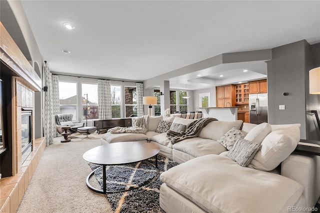 living room with light carpet, a high end fireplace, and recessed lighting