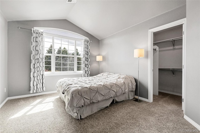 bedroom featuring lofted ceiling, a closet, carpet flooring, visible vents, and a walk in closet