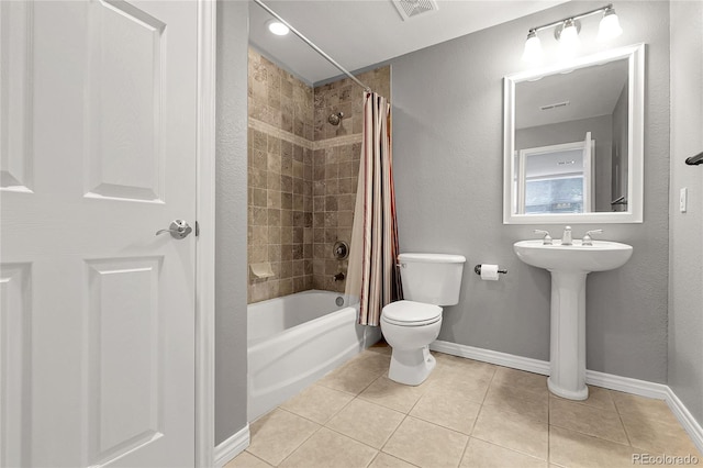 full bathroom with toilet, shower / tub combo with curtain, visible vents, tile patterned floors, and baseboards