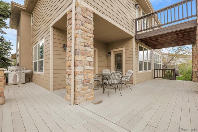 wooden terrace with area for grilling and outdoor dining area