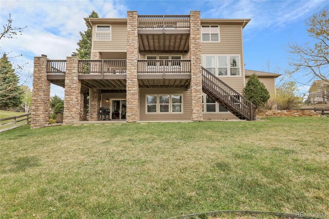 rear view of property featuring a deck and a lawn
