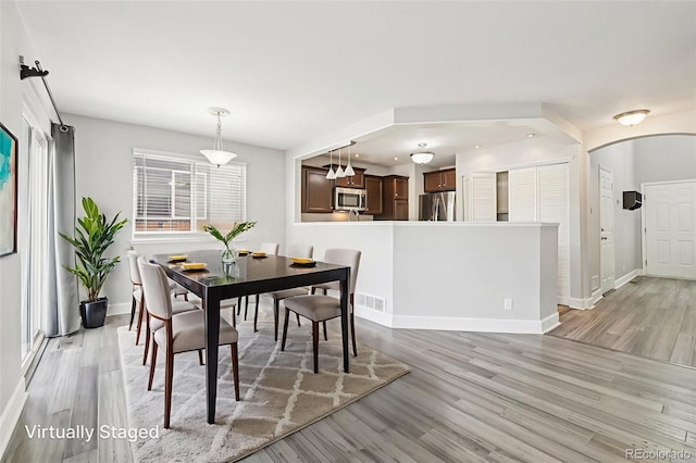 2125 E 103rd Ave, Thornton, CO 80229 - dining space featuring light wood finished floors and arched walkways