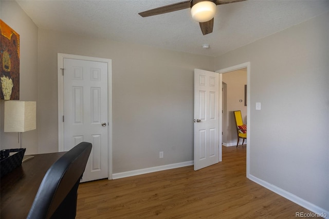 office featuring baseboards, ceiling fan, and wood finished floors