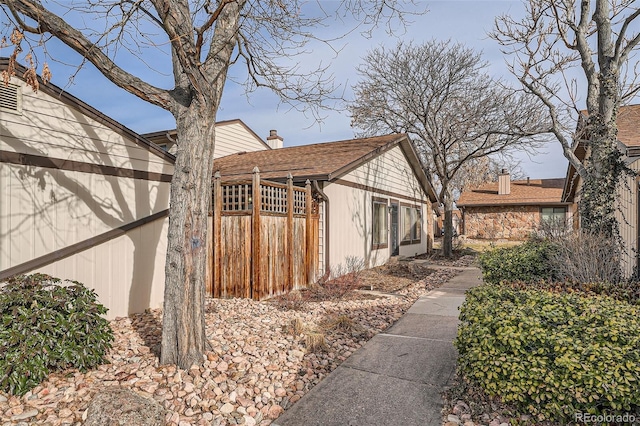 view of side of home featuring fence