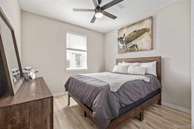 bedroom with light wood-style floors, ceiling fan, and baseboards
