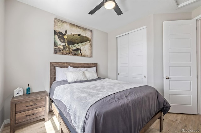 bedroom featuring a closet, light wood-style flooring, ceiling fan, and baseboards