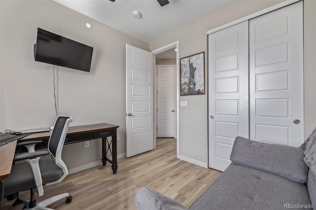 office area with light wood finished floors, baseboards, and a ceiling fan