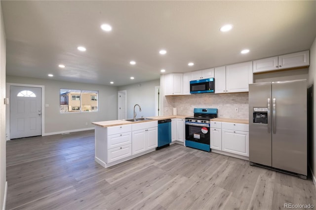 kitchen featuring appliances with stainless steel finishes, sink, white cabinets, and kitchen peninsula