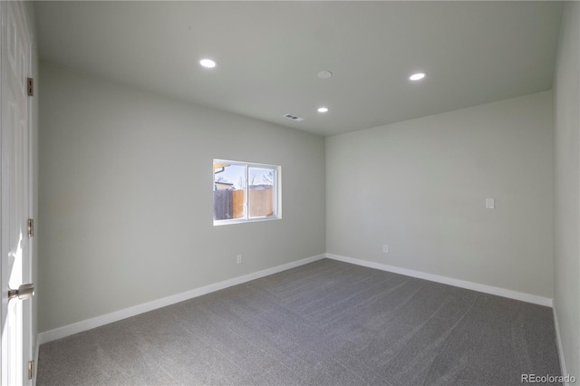 spare room featuring radiator heating unit and dark colored carpet