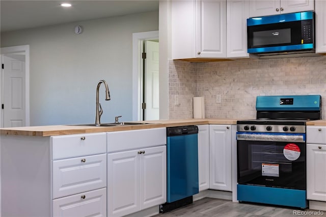 kitchen with sink, stainless steel stove, dishwasher, white cabinetry, and decorative backsplash