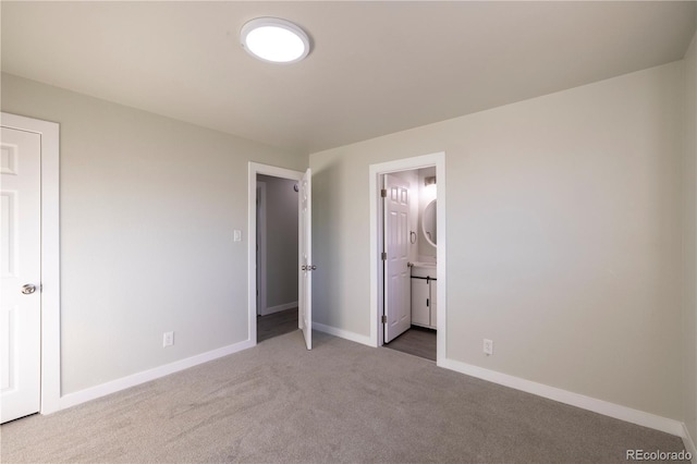 unfurnished bedroom featuring ensuite bath and carpet