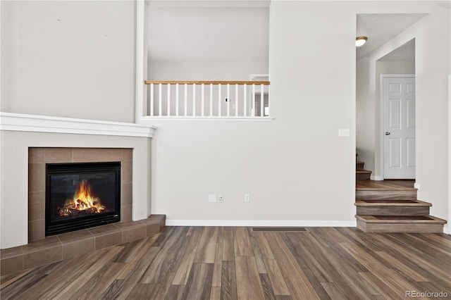 unfurnished living room with hardwood / wood-style flooring and a tile fireplace