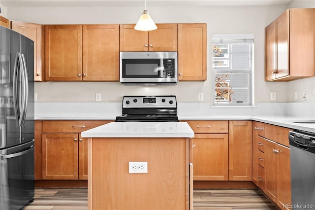 kitchen with appliances with stainless steel finishes, a center island, light hardwood / wood-style floors, and hanging light fixtures